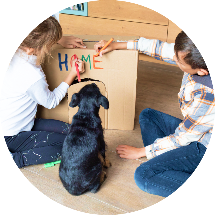 Kinderen versieren samen een kartonnen huis